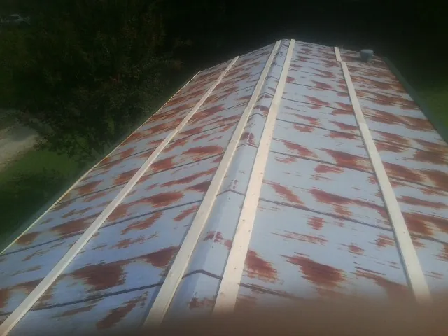 Rusted metal roof panels with new wood purlins before replacement — Storm Damage Roof Repair in Brightwaters by Roofing Brothers