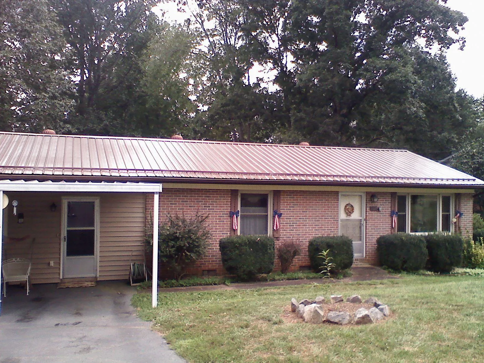 Bronze metal roof and carport on a brick ranch home — Roof Repair work by our crew in Brightwaters